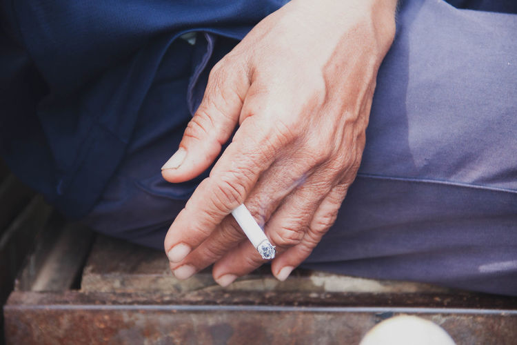 High angle view of man holding cigarette