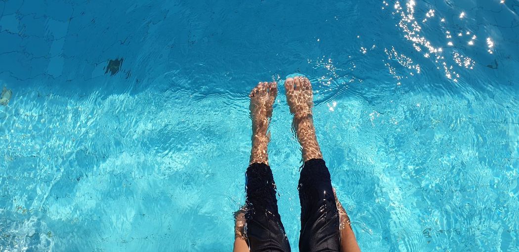Low section of person against swimming pool