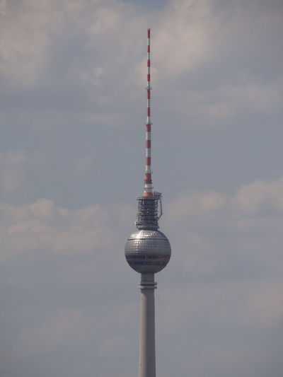 Communications tower against cloudy sky