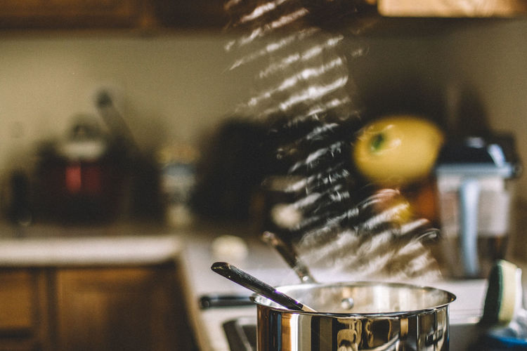 Close-up of steam emitting from kitchen utensil at home