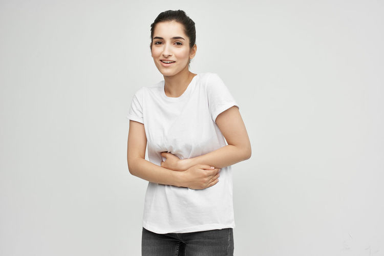 Portrait of a smiling young woman against white background