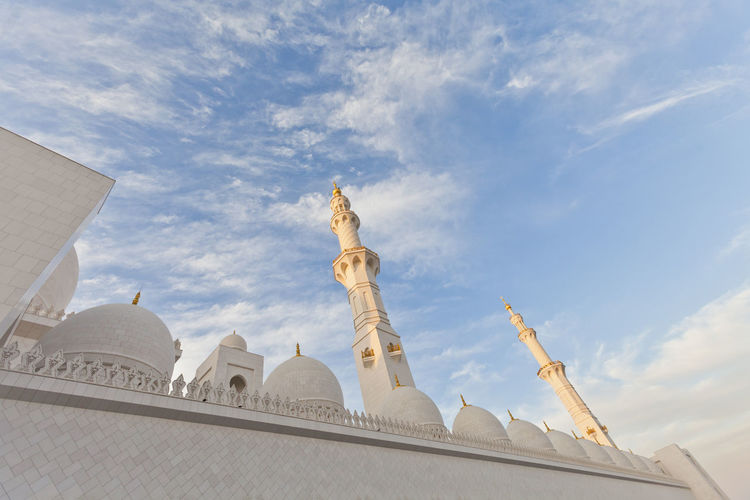 Minarets and domes of the sheikh zayed grand mosque against blue skies in abu dhabi, uae