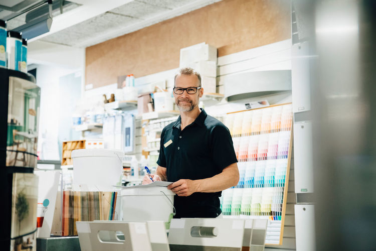 Portrait of smiling employee working in hardware store