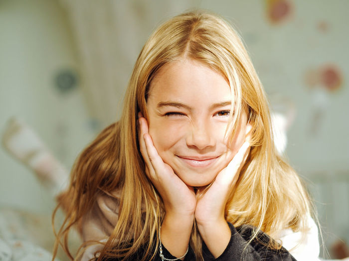 Portrait of cute girl lying on bed at home