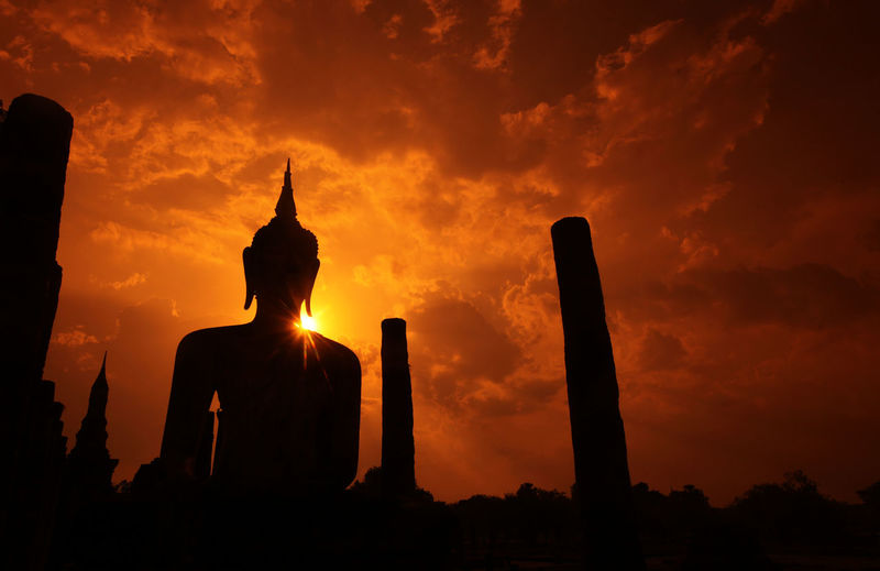 Low angle view of silhouette buddha statue