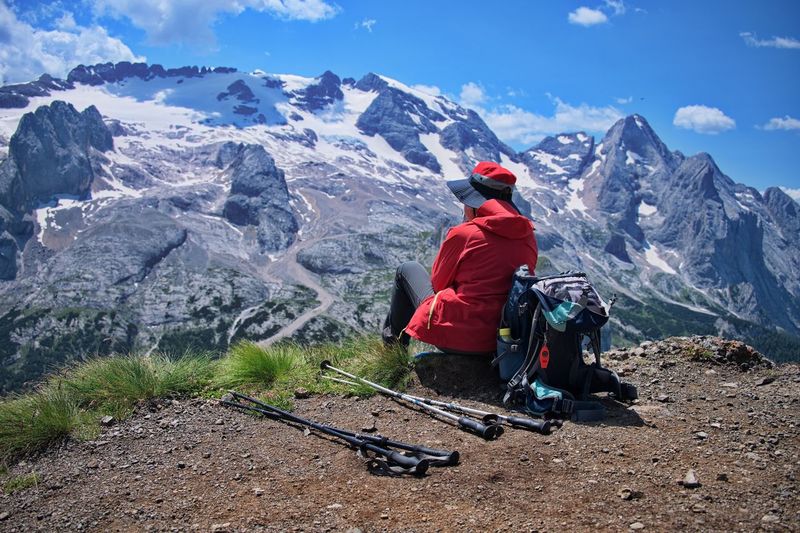 Senior woman sitting on mountain peak with beautiful view in background