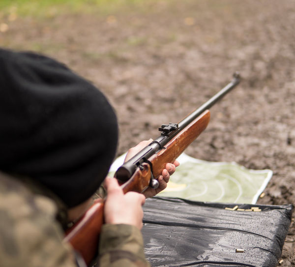 Woman aiming with gun at ground