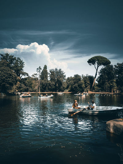 People on lake against sky