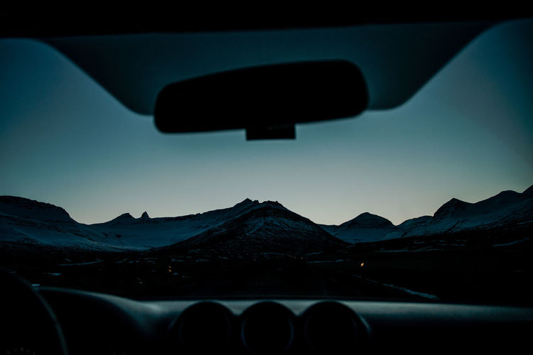 Scenic view of mountains seen through car windshield