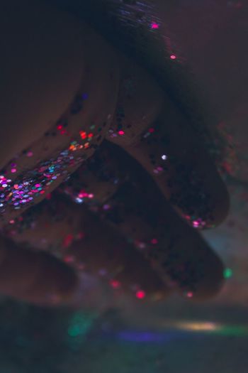 Cropped hand of person with glitter on floor