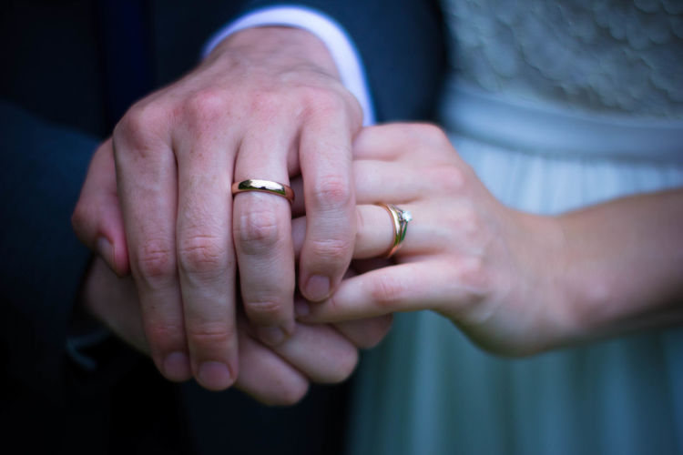 Extreme close up of wedding rings on couple