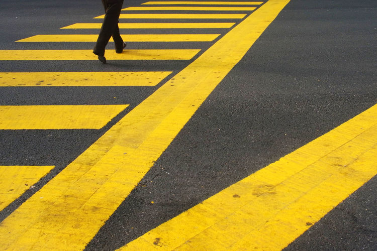 Low section of woman walking on zebra crossing