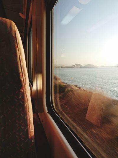 Scenic view of sea seen through train window
