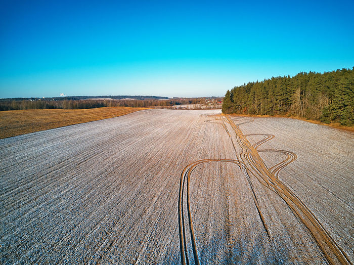 Winter agricultural field under snow. aerial scene. december rural landscape. countryside top view.