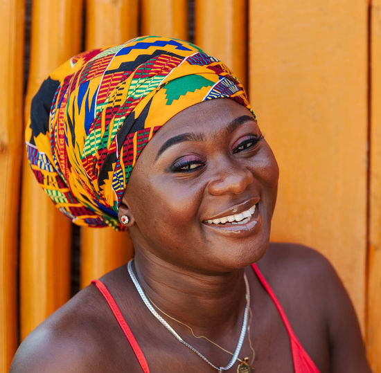 Happy african woman in the small village of keta located in ghana, dressed in african headdress