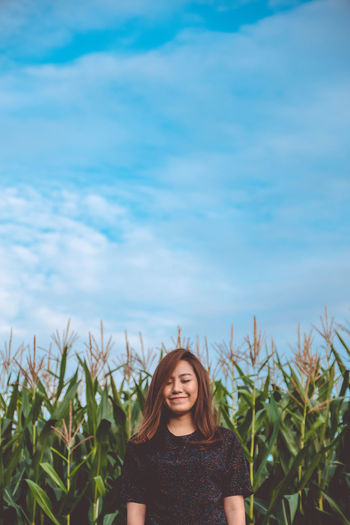 Portrait of a smiling young woman standing on land