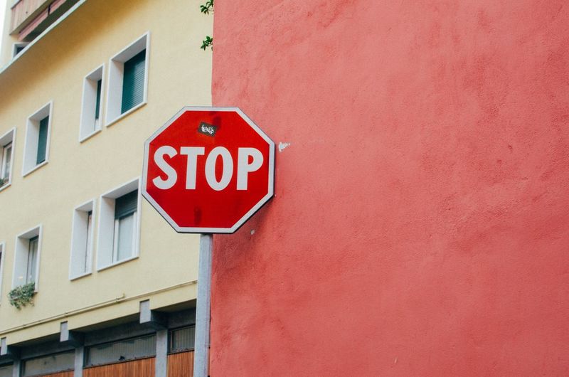 Road sign against red wall