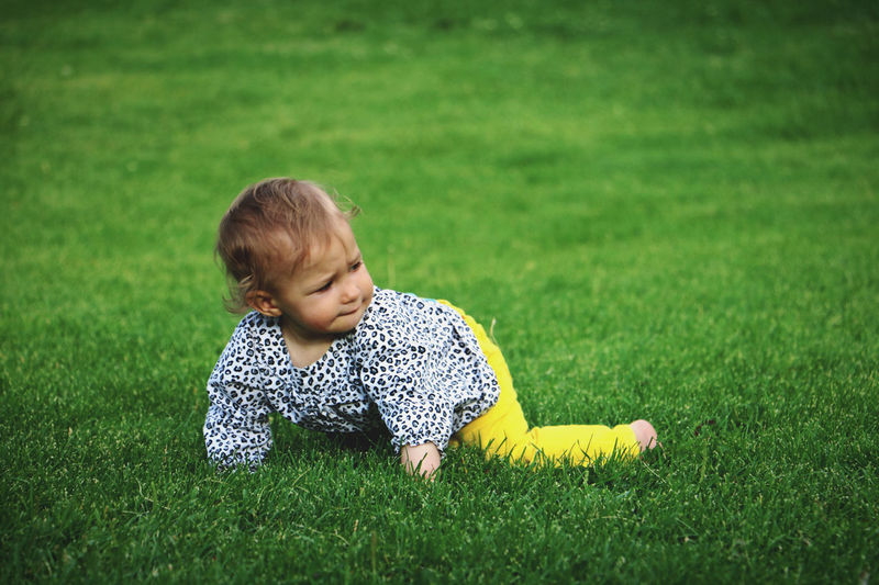 Portrait of boy playing with ball on grass