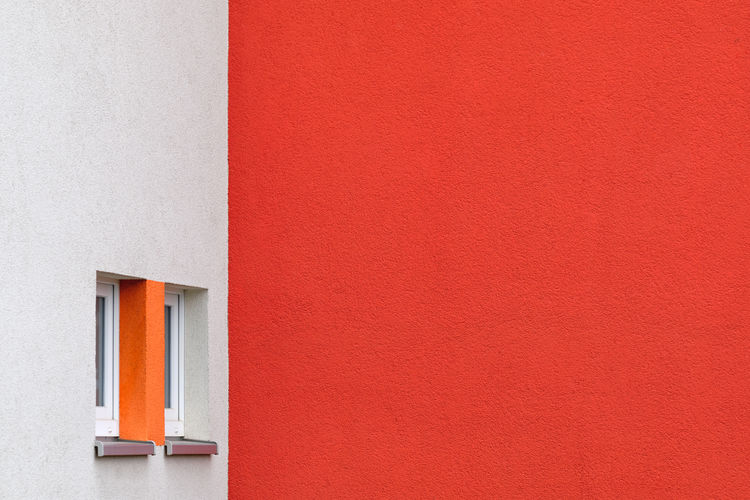 CLOSE-UP OF ORANGE WALL WITH RED DOOR