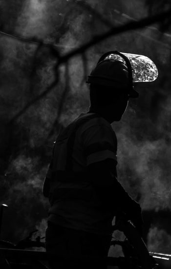 Silhouette firefighter against smoke at night