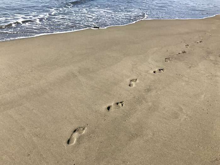 High angle view of footprints on sand at beach