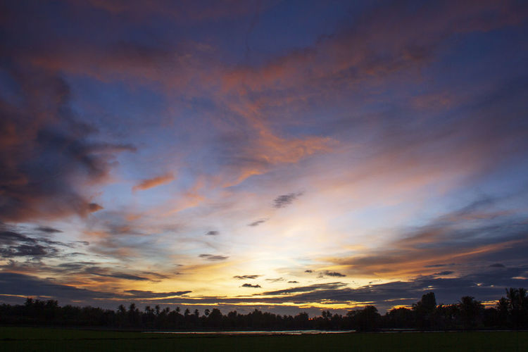 Scenic view of silhouette field against sky at sunset