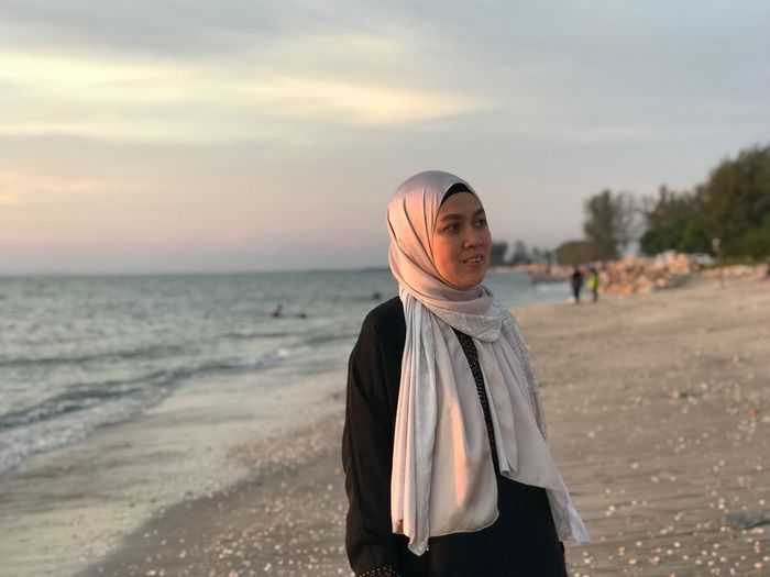 Mature woman wearing hijab standing at beach