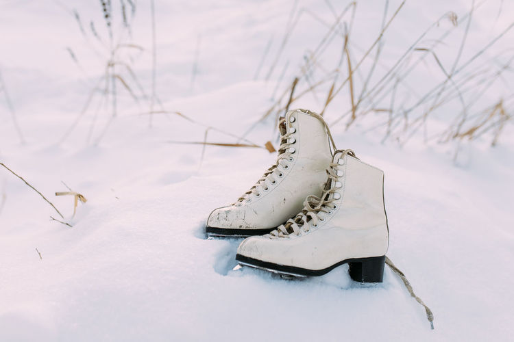 Close-up of white shoes on snow covered field