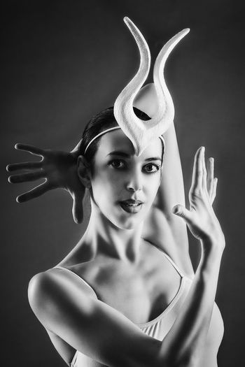 Portrait of ballerina dancing against black background