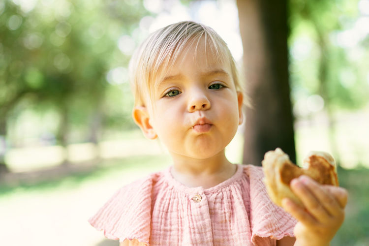 Portrait of cute boy eating outdoors