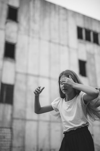 Low angle view of girl standing against building