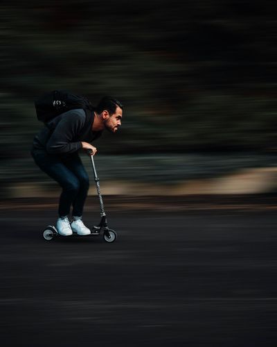 Full length of man on push scooter