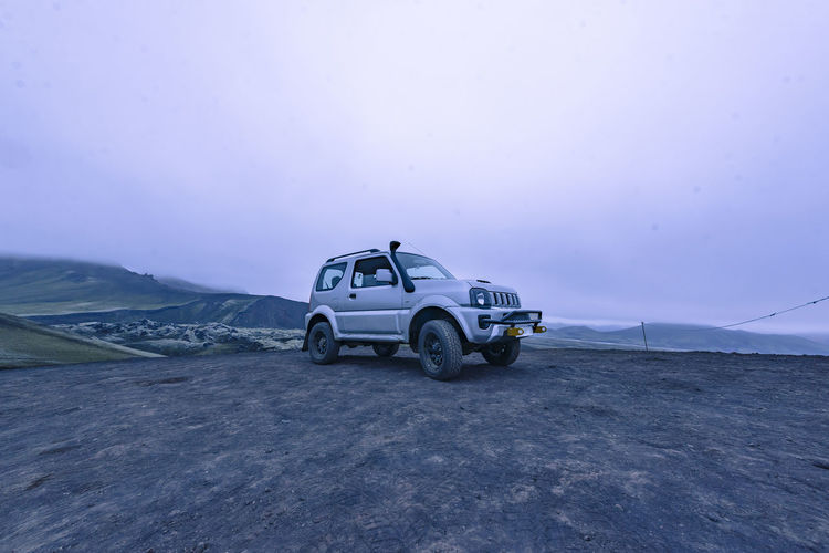 4x4 parked on top of hill in highlands iceland next to volcano