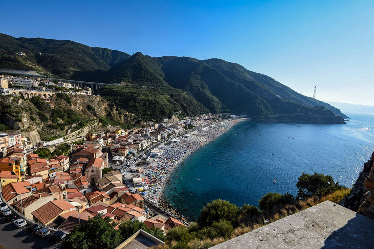 High angle view of townscape by sea against sky