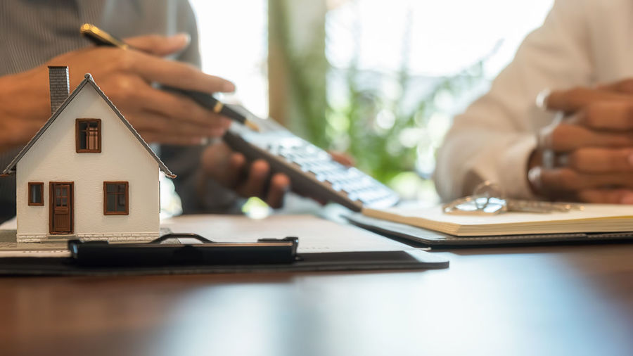 Cropped hands of real estate agent sitting with customer in office