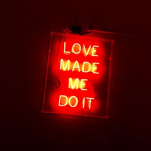 Low angle view of illuminated sign against black background