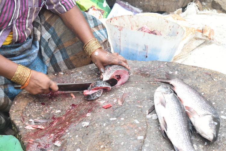 Midsection of man holding fish at market
