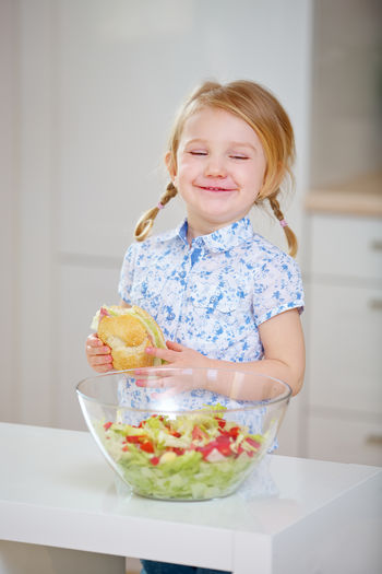 Smiling girl eating food at home
