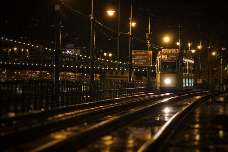 Railroad tracks in city at night