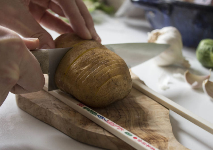 View of person slicing potatoes