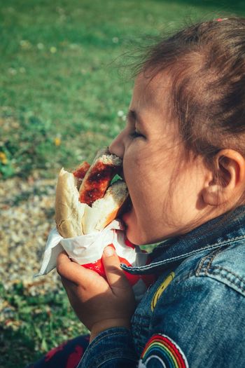 Close-up of girl eating food outdoors