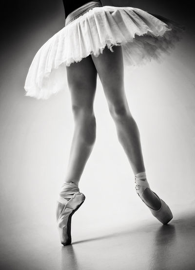 A photo of a ballerina's legs in pointes showing a pa during a performance