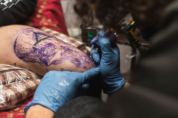 Tattooist working with client in salon