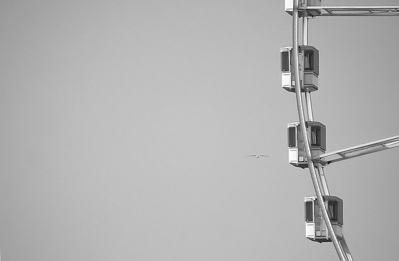 Close-up of electric lamp hanging against sky