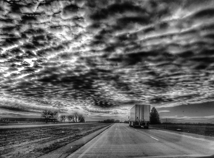 Car on highway against storm clouds