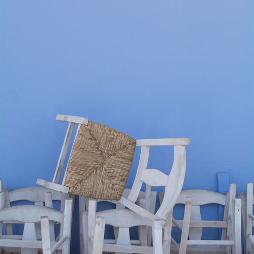 White greek chairs against blue wall