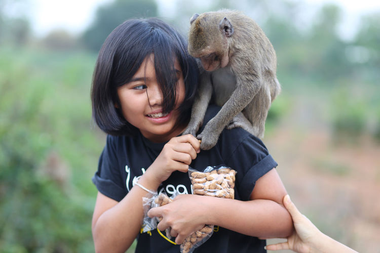 Close-up of girl feeding monkey