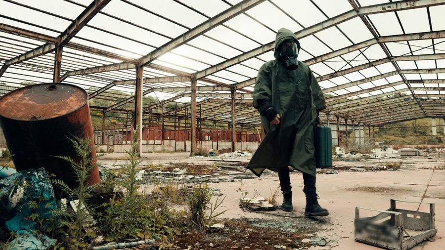 Man with gas mask walks in an abandoned place