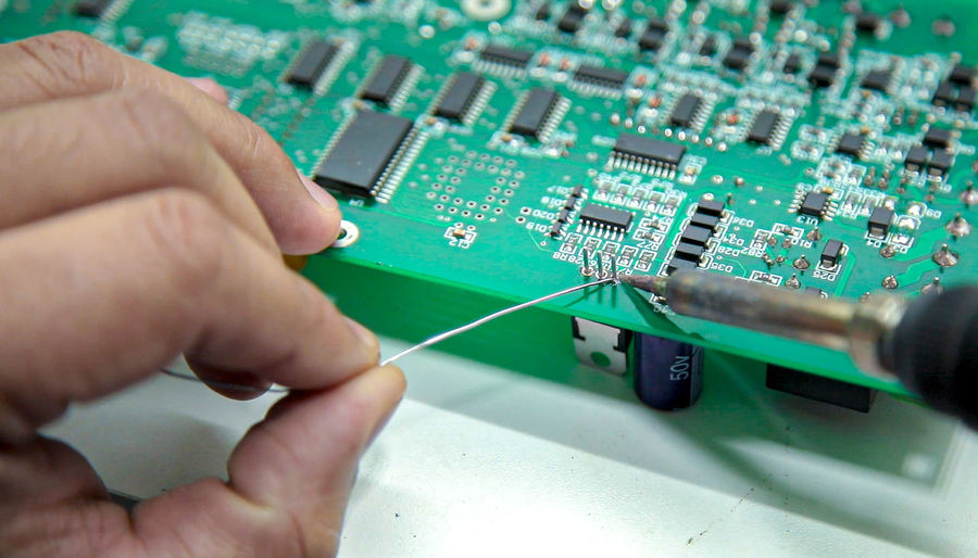 Cropped hand of worker examining mother board