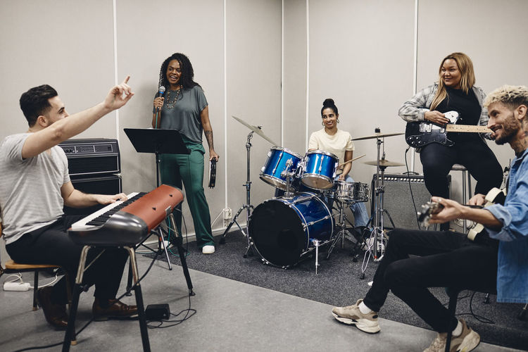 Multiracial men and women rehearsing together in classroom